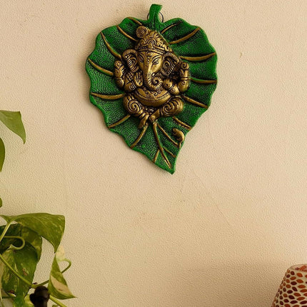 eCraftIndia Metal Golden Lord Ganesha On Green Leaf Wall Hanging Sculpture